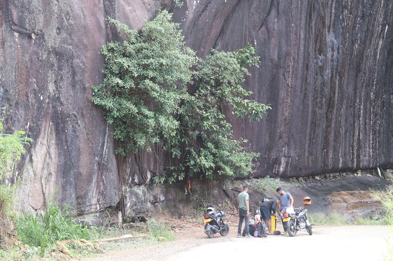 A group of tourists on a bike roadtrip in Sri Lanka parked near a cliff face